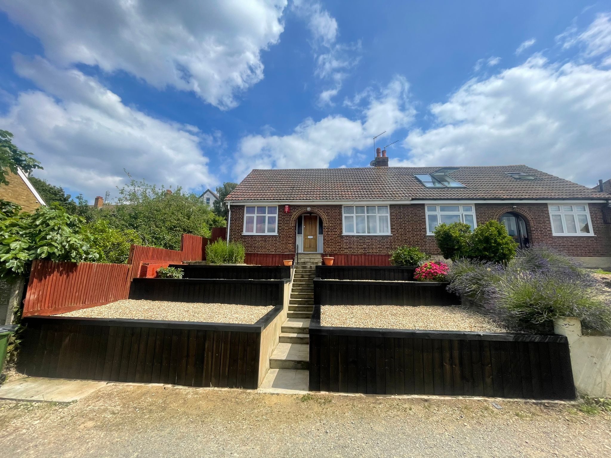 The same front garden after restoration with gravel beds, planting and dark timber walls