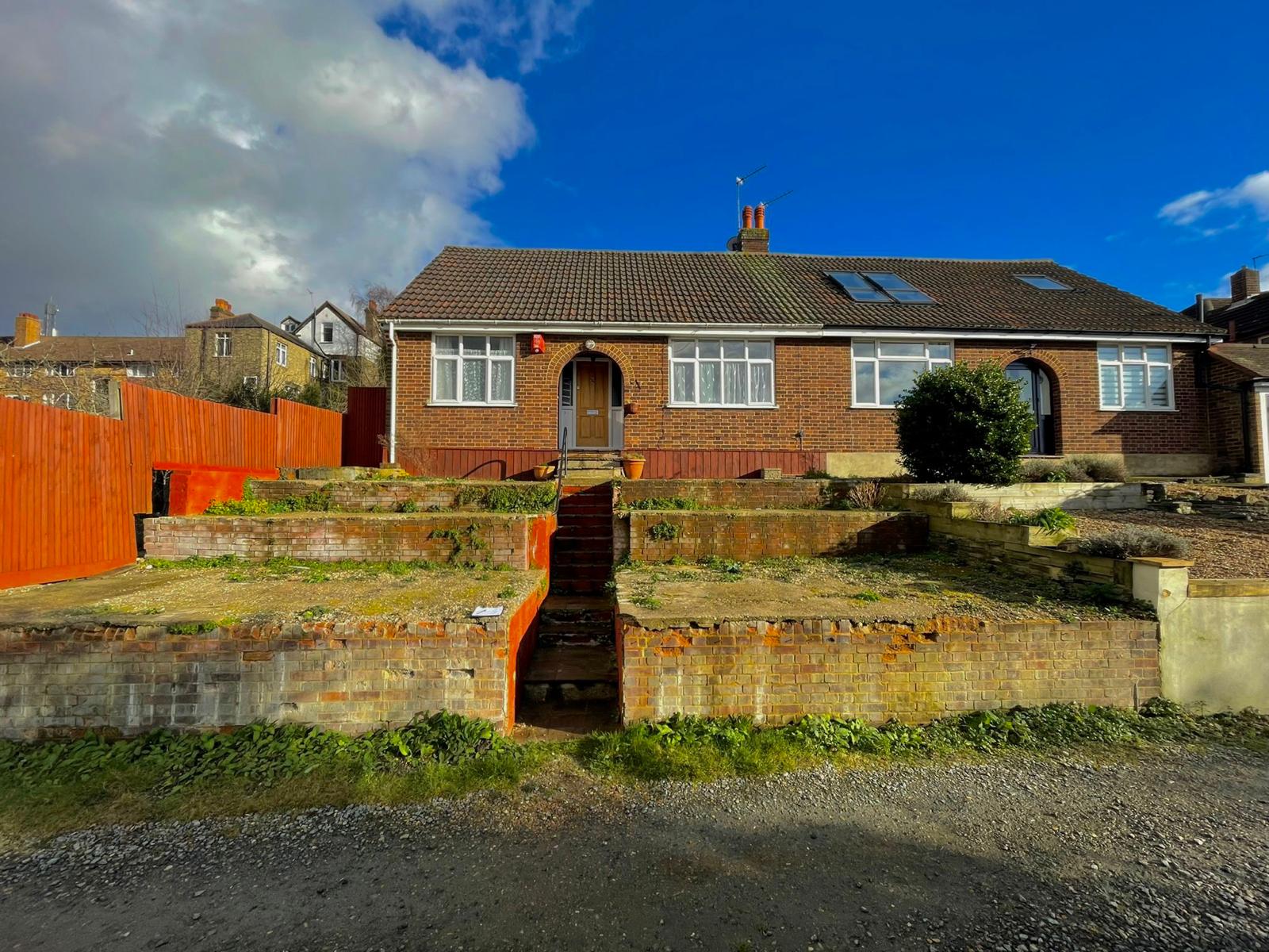 Front garden before restoration with bare beds and weathered retaining walls