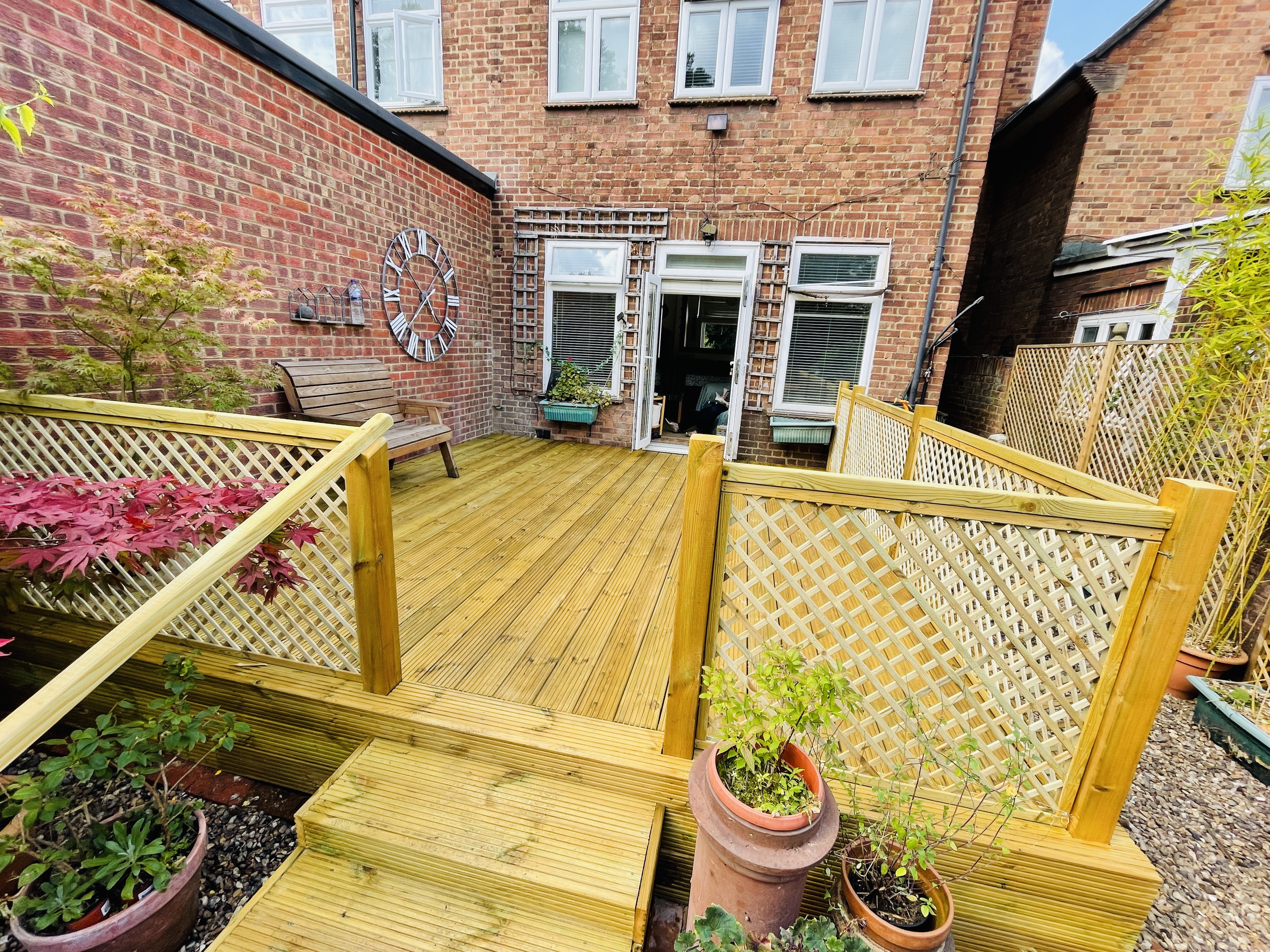 The same rear garden completed with a new raised timber deck and lattice balustrade